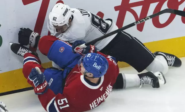 Los Angeles Kings' Caleb Jones (82) runs into Montreal Canadiens' Emil Heineman (51) during first-period NHL hockey game action Thursday, Oct. 17, 2024, in Montreal. (Ryan Remiorz/The Canadian Press via AP)