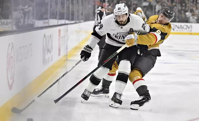 Los Angeles Kings center Phillip Danault (24) and Vegas Golden Knights center Jack Eichel (9) battle for the puck during the first period of an NHL hockey game Tuesday, Oct. 22, 2024, in Las Vegas. (AP Photo/David Becker)