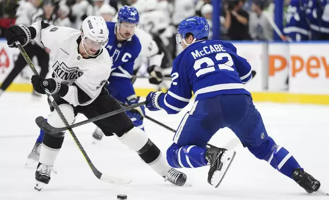 Los Angeles Kings' Adrian Kempe (9) tries to get by Toronto Maple Leafs' Jake McCabe (22) during the first period of an NHL hockey game, Wednesday, Oct. 16, 2024 in Toronto. (Frank Gunn/The Canadian Press via AP)