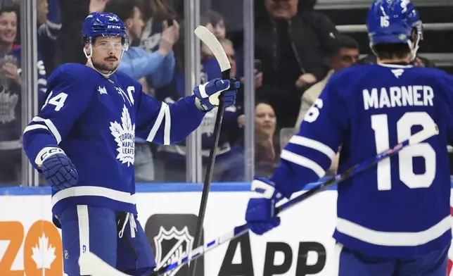 Toronto Maple Leafs' Auston Matthews (34) celebrates his goal against the Los Angeles Kings with Mitch Marner (16) during the first period of an NHL hockey game, Wednesday, Oct. 16, 2024 in Toronto. (Frank Gunn/The Canadian Press via AP)