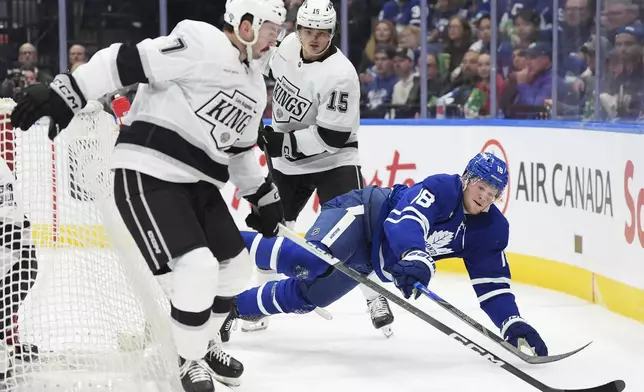 Toronto Maple Leafs' Steven Lorentz (18) falls between Los Angeles Kings' Kyle Burroughs (7) and Alex Turcotte (15) during the second period of an NHL hockey game, Wednesday, Oct. 16, 2024 in Toronto. (Frank Gunn/The Canadian Press via AP)