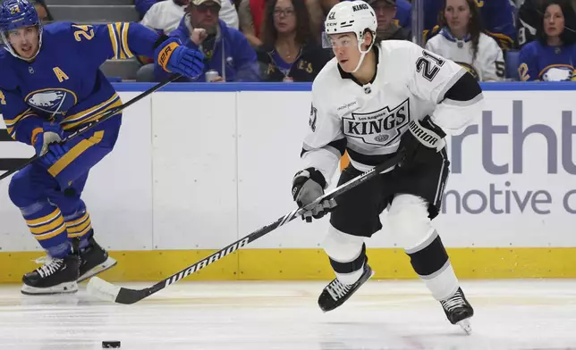 Los Angeles Kings defenseman Jordan Spence (21) carries the puck out of the zone during the first period of an NHL hockey game against the Buffalo Sabres Thursday, Oct. 10, 2024, in Buffalo, N.Y. (AP Photo/Jeffrey T. Barnes)