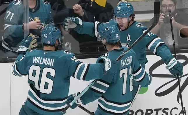 San Jose Sharks center Tyler Toffoli, right, celebrates with defenseman Jake Walman (96) and left wing William Eklund (72) after scoring against the Los Angeles Kings during the third period of an NHL hockey game in San Jose, Calif., Tuesday, Oct. 29, 2024. (AP Photo/Jeff Chiu)