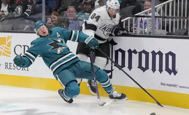 Los Angeles Kings defenseman Vladislav Gavrikov (84) reaches for the puck next to San Jose Sharks center Tyler Toffoli (73) during the first period of an NHL hockey game in San Jose, Calif., Tuesday, Oct. 29, 2024. (AP Photo/Jeff Chiu)