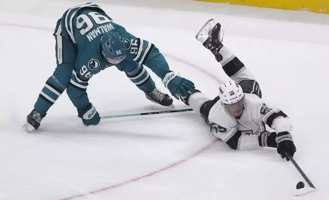 Los Angeles Kings right wing Quinton Byfield, right, reaches for the puck in front of San Jose Sharks defenseman Jake Walman (96) during the third period of an NHL hockey game in San Jose, Calif., Tuesday, Oct. 29, 2024. (AP Photo/Jeff Chiu)