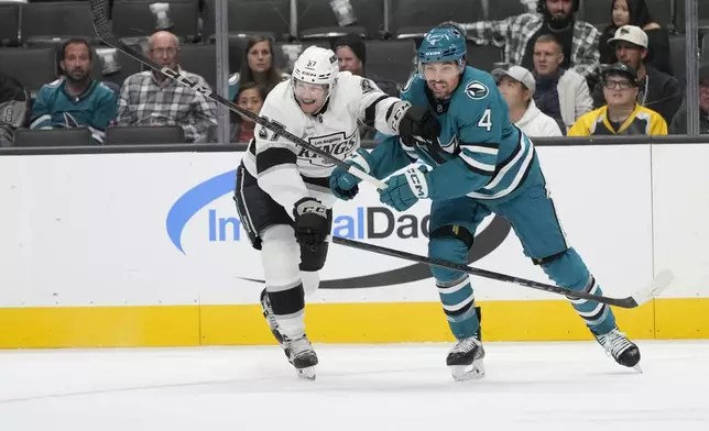 Los Angeles Kings left wing Warren Foegele, left, skates toward the puck next to San Jose Sharks defenseman Cody Ceci (4) during the second period of an NHL hockey game in San Jose, Calif., Tuesday, Oct. 29, 2024. (AP Photo/Jeff Chiu)