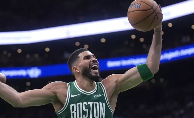 Boston Celtics forward Jayson Tatum grabs a rebound against the New York Knicks during the first half of an NBA basketball game, Tuesday, Oct. 22, 2024, in Boston. (AP Photo/Charles Krupa)