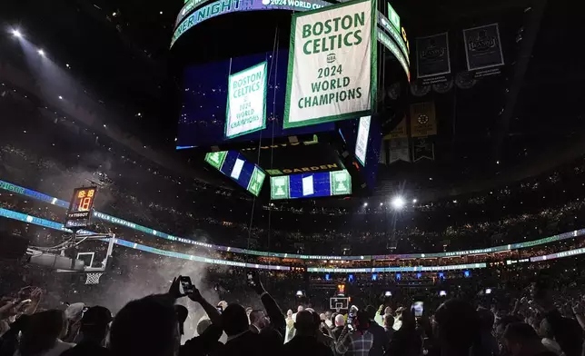 The Boston Celtics 2024 World Championship banner is raised prior to an NBA basketball game against the New York Knicks, Tuesday, Oct. 22, 2024, in Boston. (AP Photo/Charles Krupa)