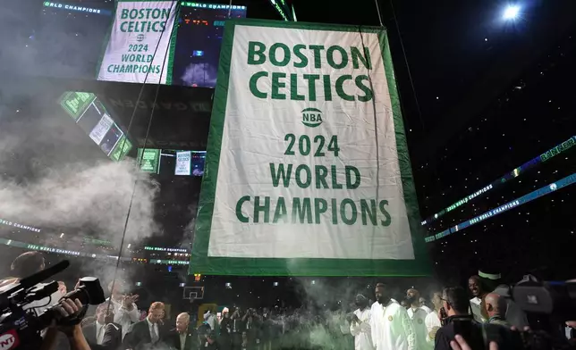 The Boston Celtics 2024 World Championship banner is raised prior to an NBA basketball game against the New York Knicks, Tuesday, Oct. 22, 2024, in Boston. (AP Photo/Charles Krupa)