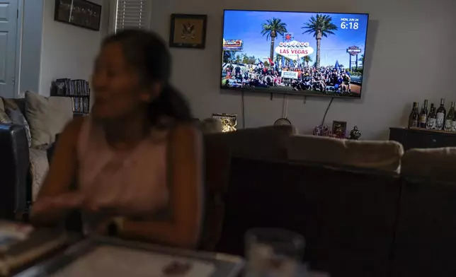 An image of a veterans support gathering Leah Elmquist attended is displayed on the television as she sits in her home, Monday, June 24, 2024, in Las Vegas. "That's why I joined the military. I felt so lucky to be an American, ironically. I wanted to thank this country for raising me," she said. "I didn't think about citizenship because I felt I was being more American than most Americans." (AP Photo/David Goldman)