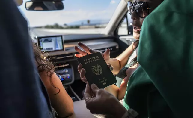 Joy Alessi, right, shows off her Korean passport while traveling to dinner with fellow adoptees, Sunday June 23, 2024, in Las Vegas. (AP Photo/David Goldman)