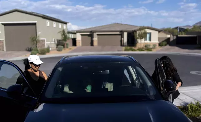 Joy Alessi, left, and fellow adoptee Buttons, get in a car as they leave Alessi's home Monday, June 24, 2024, in Henderson, Nev. Alessi anointed her friend Buttons "an honorary Korean." This problem they have both endured was born there, in Alessi's motherland, and to her it represents the most glaring example of the neglectful system that brought them here. (AP Photo/David Goldman)