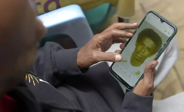 Mike Davis, 61, looks at a photo of him as a teenager, Friday, Aug. 23, 2024, in Addis Ababa, Ethiopia. Davis has five grandchildren he's never met. His youngest son, Adam, 26 now, recently moved into his first apartment, and thought how nice it would be to have his father there to see it. (AP Photo)