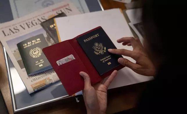 Navy veteran Leah Elmquist holds her U.S. passport in her home, Monday, June 24, 2024, in Las Vegas. She was naturalized in 2022, the day before her 40th birthday and used her new passport for the first time to travel to Paris for the 2024 Summer Olympics. (AP Photo/David Goldman)