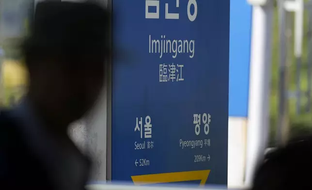 A visitor walks past a signboard showing the distance to North Korea's capital Pyongyang and to South Korea's capital Seoul from Imjingang Station in Paju, South Korea, Wednesday, Oct. 9, 2024. (AP Photo/Lee Jin-man)