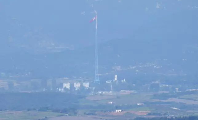 A North Korean flag flutters in the wind atop a 160-meter (525-foot) tower in the North's Kijong-dong village near the truce village of Panmunjom, seen from Paju, South Korea, near the border with North Korea, Wednesday, Oct. 9, 2024. (AP Photo/Lee Jin-man)