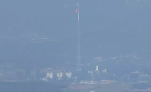 A North Korean flag flutters in the wind atop a 160-meter (525-foot) tower in the North's Kijong-dong village near the truce village of Panmunjom, seen from Paju, South Korea, near the border with North Korea, Wednesday, Oct. 9, 2024. (AP Photo/Lee Jin-man)