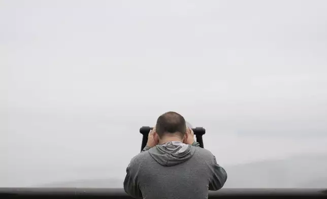 A visitor uses binoculars to see the North Korean side from the unification observatory in Paju, South Korea, Tuesday, Oct. 15, 2024. (AP Photo/Lee Jin-man)