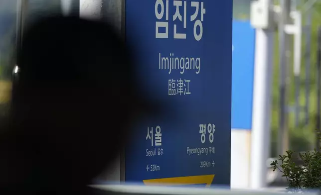 A visitor walks past near a signboard showing the distance to North Korea's capital Pyongyang and to South Korea's capital Seoul from Imjingang Station in Paju, South Korea, Wednesday, Oct. 9, 2024. (AP Photo/Lee Jin-man)