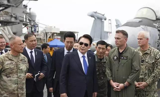 FILE - South Korean President Yoon Suk Yeol, center, boards the USS Theodore Roosevelt aircraft carrier at the South Korean naval base in Busan, South Korea, June 25, 2024. (South Korean Presidential Office/Yonhap via AP, File)