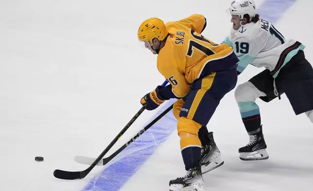 Nashville Predators defenseman Brady Skjei (76) skates the puck past Seattle Kraken left wing Jared McCann (19) during the third period of an NHL hockey game Tuesday, Oct. 15, 2024, in Nashville, Tenn. (AP Photo/George Walker IV)