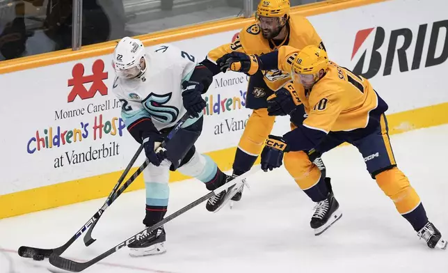 Seattle Kraken right wing Oliver Bjorkstrand (22) passes the puck past Nashville Predators defenseman Roman Josi (59) and center Colton Sissons (10) during the third period of an NHL hockey game Tuesday, Oct. 15, 2024, in Nashville, Tenn. (AP Photo/George Walker IV)