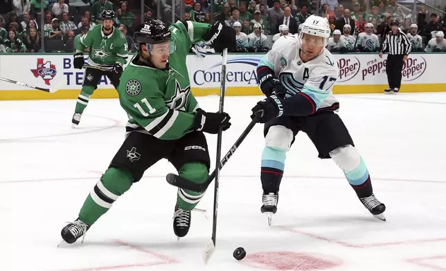 Dallas Stars center Logan Stankoven (11) and Seattle Kraken center Jaden Schwartz (17) battle for the puck in the first period during an NHL hockey game Sunday, Oct. 13, 2024, in Dallas. (AP Photo/Richard W. Rodriguez)