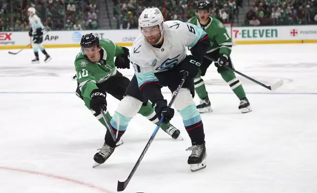 Dallas Stars center Oskar Back (10) tries to get the puck from Seattle Kraken center Shane Wright (51) in the second period during an NHL hockey game on Sunday, Oct. 13, 2024, in Dallas. (AP Photo/Richard W. Rodriguez)