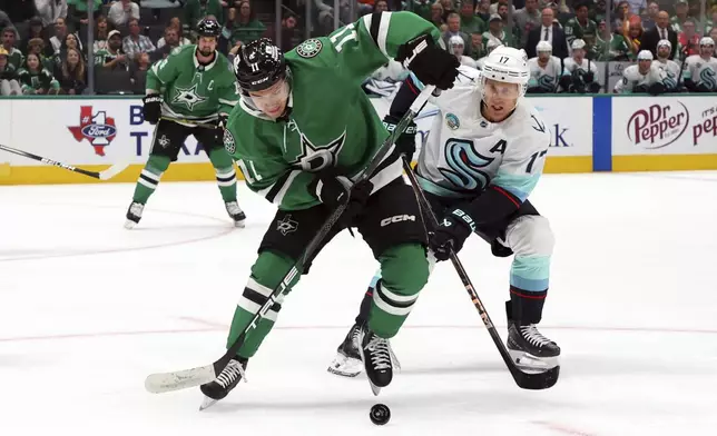 Dallas Stars center Logan Stankoven (11) and Seattle Kraken center Jaden Schwartz (17) battle for the puck in the first period during an NHL hockey game Sunday, Oct. 13, 2024, in Dallas. (AP Photo/Richard W. Rodriguez)