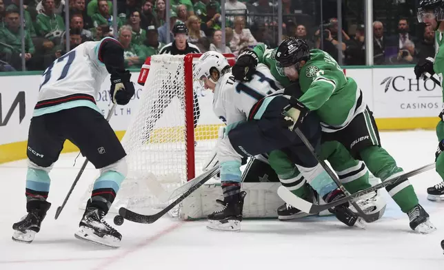 Seattle Kraken left wing Brandon Tanev (13) tries to score Dallas Stars defenseman Ilya Lyubushkin (46) defends in the second period during an NHL hockey game on Sunday, Oct. 13, 2024, in Dallas. (AP Photo/Richard W. Rodriguez)