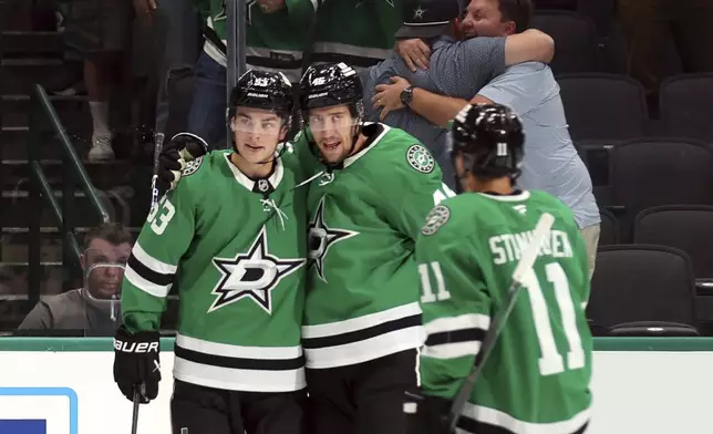 Dallas Stars center Wyatt Johnston (53) celebrates after his first-period goal against the Seattle Kraken with defenseman Ilya Lyubushkin (46) and center Logan Stankoven (11) during an NHL hockey game Sunday, Oct. 13, 2024, in Dallas. (AP Photo/Richard W. Rodriguez)