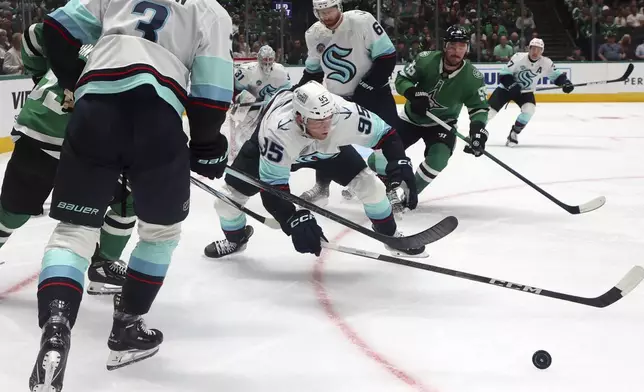 Seattle Kraken defenseman Will Borgen (3), Kraken left wing Andre Burakovsky (95) and Dallas Stars defenseman Thomas Harley (55) chase the puck in the first period during an NHL hockey game Sunday, Oct. 13, 2024, in Dallas. (AP Photo/Richard W. Rodriguez)