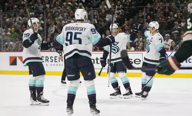 Seattle Kraken right wing Jordan Eberle (7) celebrates with teammates after scoring during the second period of an NHL hockey game against the Minnesota Wild, Saturday, Oct. 12, 2024, in St. Paul, Minn. (AP Photo/Abbie Parr)