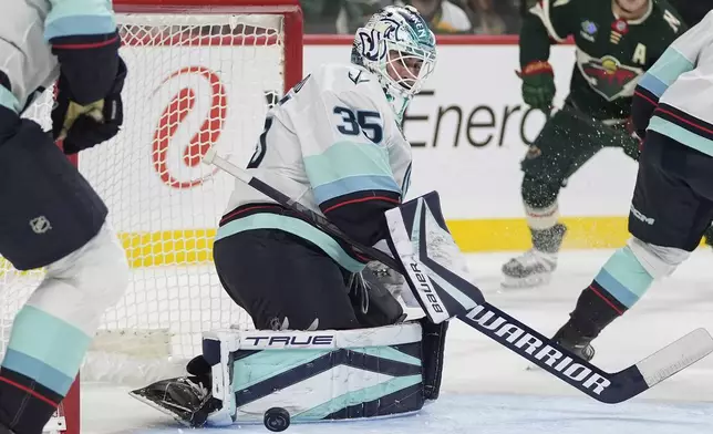 Seattle Kraken goaltender Joey Daccord (35) blocks a shot during the first period of an NHL hockey game against the Minnesota Wild, Saturday, Oct. 12, 2024, in St. Paul, Minn. (AP Photo/Abbie Parr)