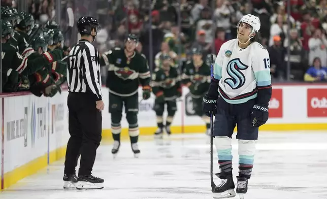 Seattle Kraken left wing Brandon Tanev (13) skates after a goal scored by Minnesota Wild left wing Matt Boldy (12) during the second period of an NHL hockey game, Saturday, Oct. 12, 2024, in St. Paul, Minn. (AP Photo/Abbie Parr)