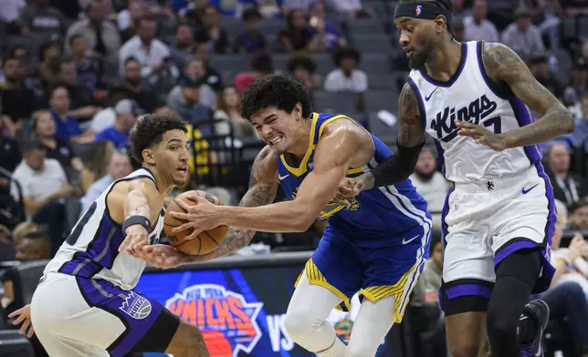 FILE - Sacramento Kings guard Colby Jones, left, and forward Jalen McDaniels guard Golden State Warriors forward Gui Santos during the second half of a preseason NBA basketball game in Sacramento, Calif., Oct. 9, 2024. The Warriors won 122-112. (AP Photo/Randall Benton, File)