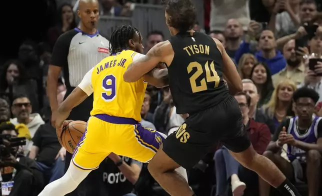 Los Angeles Lakers guard Bronny James (9) drives against Cleveland Cavaliers forward Jaylon Tyson (24) in the second half of an NBA basketball game, Wednesday, Oct. 30, 2024, in Cleveland. (AP Photo/Sue Ogrocki)