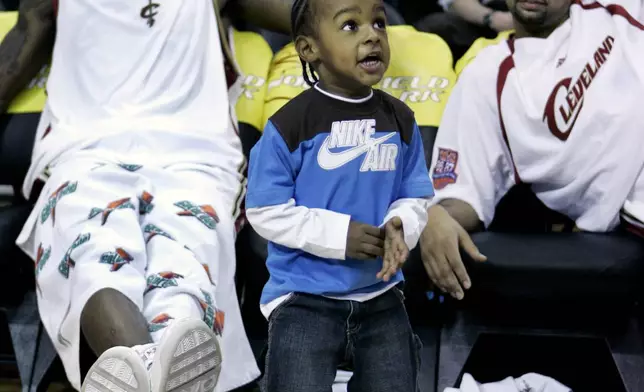 FILE - LeBron James Jr. dances on the court during a time out as his dad Cleveland Cavaliers' LeBron James, left, and Cavaliers' Drew Gooden watch in the fourth quarter of an NBA basketball game, Friday, March 23, 2007, in Cleveland. (AP Photo/Tony Dejak, File)