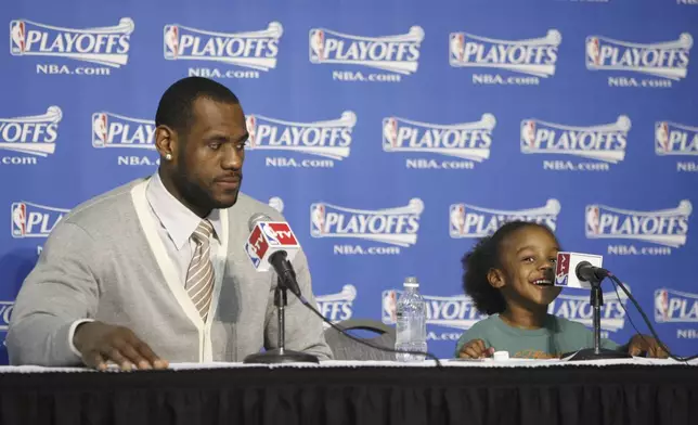 FILE - Cleveland Cavaliers LeBron James and his son LeBron James Jr. during a post game interview Saturday May 10, 2008, after the Cavaliers beat the Boston Celtics 108-84 at Quicken Loans Arena in Cleveland, Ohio. (Bob Rossiter/The Canton Repository via AP, File)
