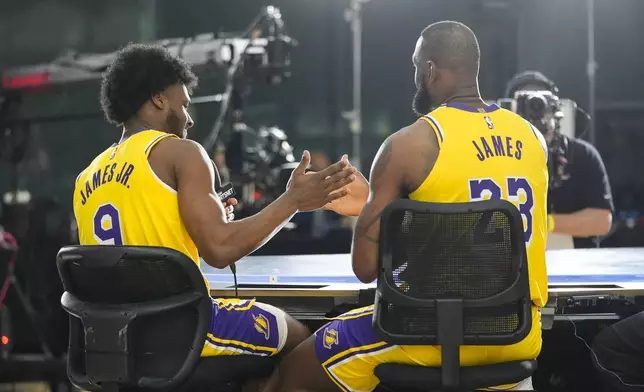 Los Angeles Lakers' LeBron James, right, and his son, Bronny James Jr, shake hands after an interview during the NBA basketball team's media day in El Segundo, Calif., Monday, Sept. 30, 2024. (AP Photo/Jae C. Hong)