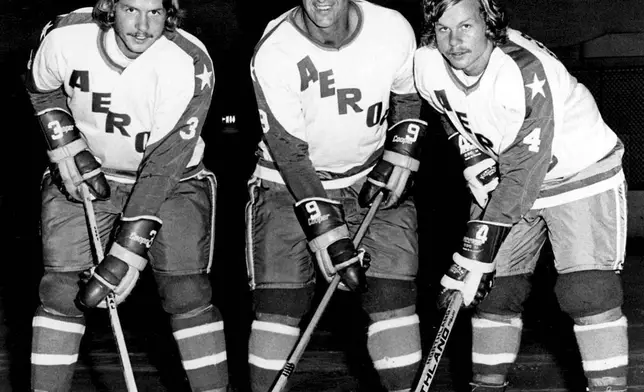 FILE - Former Detroit Red Wings great Gordie Howe, center, is flanked by sons Marty, left, and Mark as they try their new Houston Aeros uniforms in St. Clair Shores, Mich., Aug. 3, 1973. (AP Photo/The Macomb Daily, David Posavetz, File)