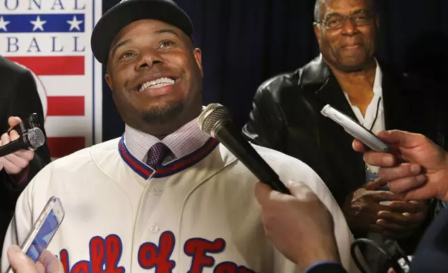 FILE - Newly-elected Baseball Hall of Fame member Ken Griffey Jr. conducts interviews with his father, Hall of Famer Ken Griffey Sr. listening in after a press conference announcing that he and Mike Piazza were elected to baseball's Hall of Fame, Thursday, Jan. 7, 2016, in New York. (AP Photo/Kathy Willens, File)