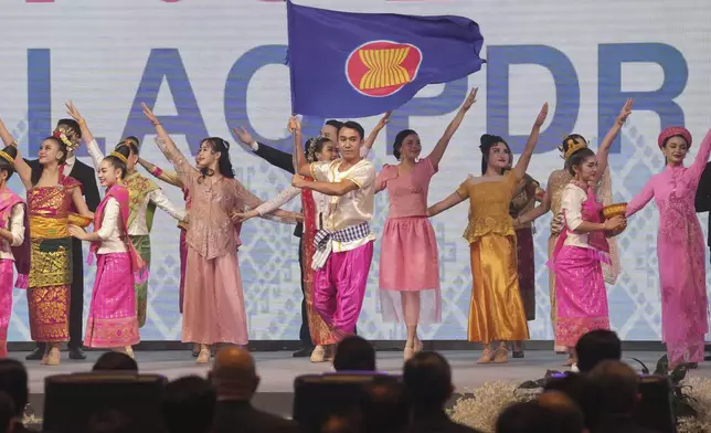 A dancer waves a ASEAN Flag as he performs during the opening ceremony of the Association of South East Asian Nations (ASEAN) Summit in Vientiane, Laos, Wednesday, Oct. 9, 2024. (AP Photo/Dita Alangkara)