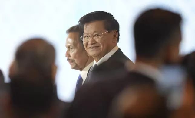 Laos' President Thongloun Sisoulith, right, walks with Brunei Sultan Hassanal Bolkiah upon arrival to attend the opening ceremony of the Association of South East Asian Nations (ASEAN) Summit in Vientiane, Laos, Wednesday, Oct. 9, 2024. (AP Photo/Dita Alangkara)