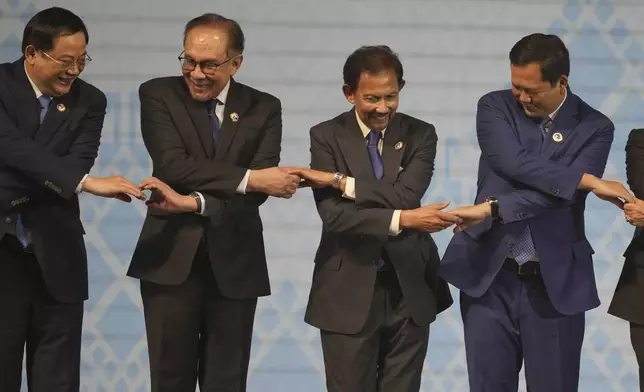 From left Laos' Prime Minister Sonexay Siphandone, Malaysian Prime Minister Anwar Ibrahim, Brunei Sultan Hassanal Bolkiah, and Cambodian Prime Minister Hun Manet hold hands for a photo session during the opening ceremony of the Association of South East Asian Nations (ASEAN) Summit in Vientiane, Laos, Wednesday, Oct. 9, 2024. (AP Photo/Dita Alangkara)