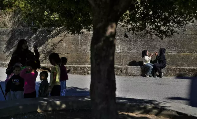 Displaced children who fled southern Lebanon with their families during the ongoing Hezbollah-Israel war play outside a school in the village of Ebrine, northern Lebanon, Thursday, Oct. 24, 2024. (AP Photo/Hassan Ammar)