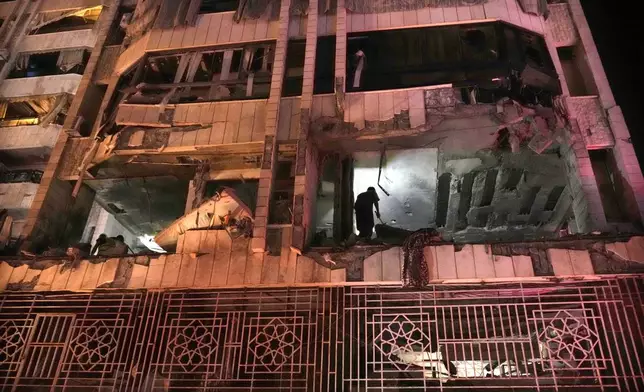 A rescue worker surveys an apartment hit by an airstrike in Beirut, Lebanon, early Thursday, Oct. 3, 2024. (AP Photo/Hussein Malla)