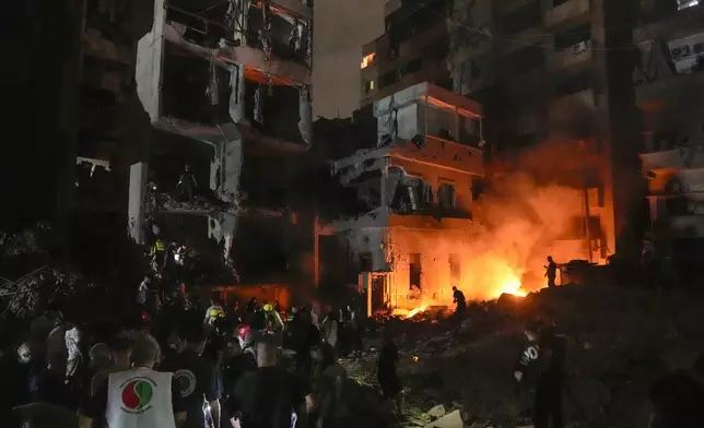 People gather in front of destroyed buildings hit by an Israeli airstrike in central Beirut, Lebanon, Thursday, Oct. 10, 2024. (AP Photo/Bilal Hussein)