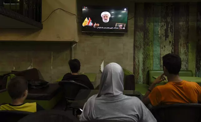 People listen to a speech by Naim Kassem, acting leader of Hezbollah, broadcasted on a television channel, at a coffee shop in Beirut, Lebanon, Tuesday, Oct. 15, 2024. (AP Photo/Bilal Hussein)