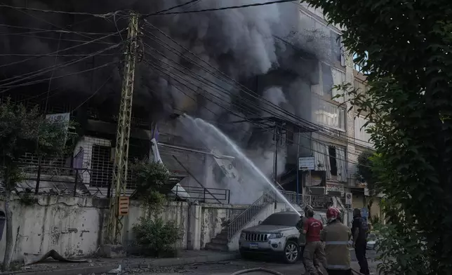 Firefighters extinguish a fire at the site of an Israeli airstrike in Dahiyeh, Beirut, Lebanon, Sunday, Oct. 6, 2024. (AP Photo/Bilal Hussein)